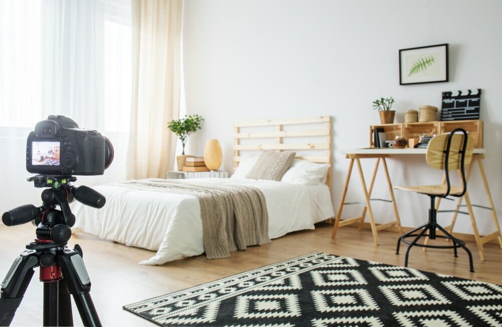 Kamera auf Stativ zeigt auf ein schön eingerichtetes Schlafzimmer